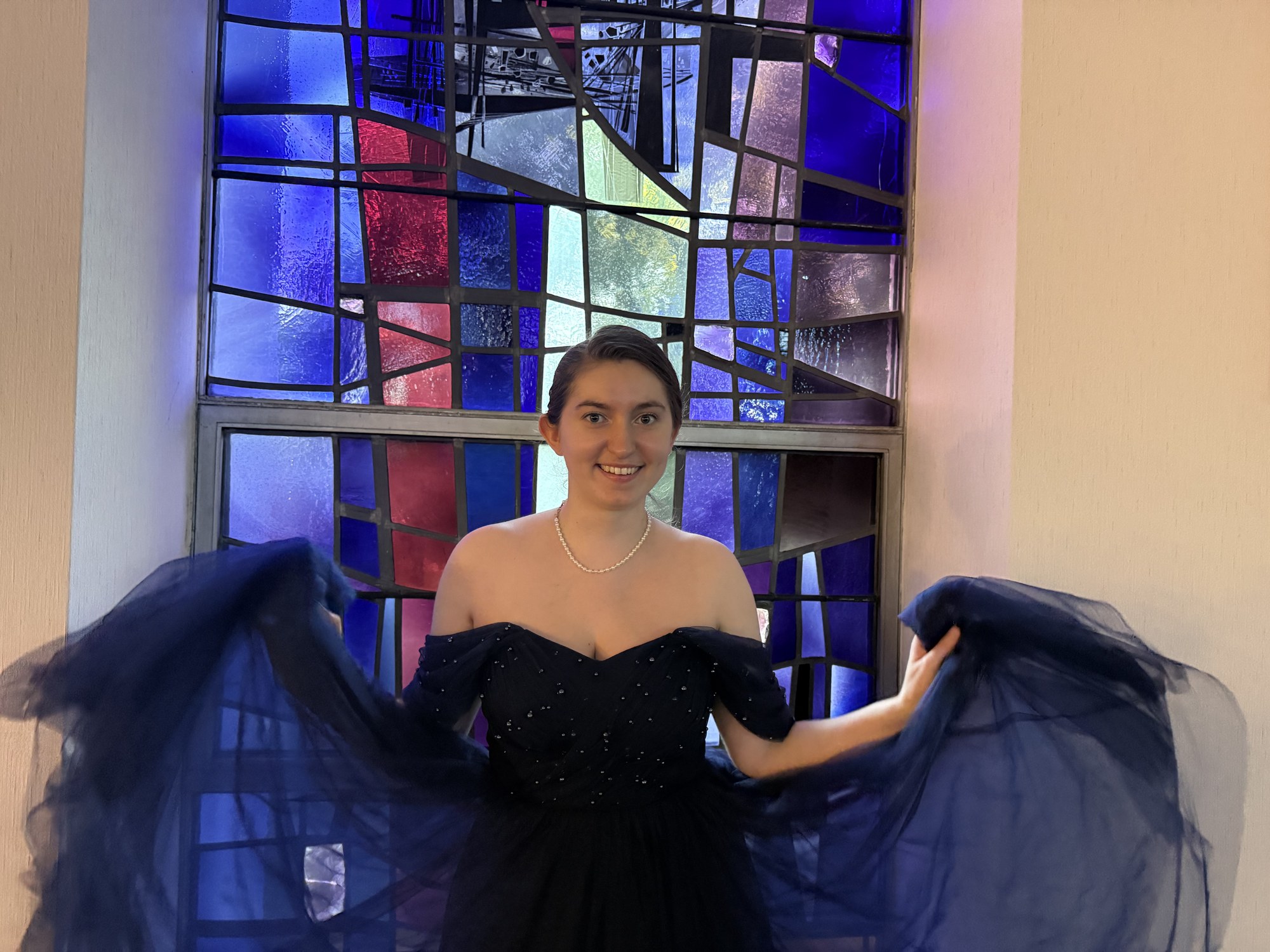 LeAnne Weber twirling in a dress before a stained-glass window